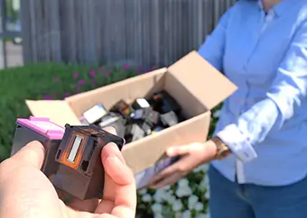 Une personne montrant son colis de cartouches d'encre vides pour son rachat